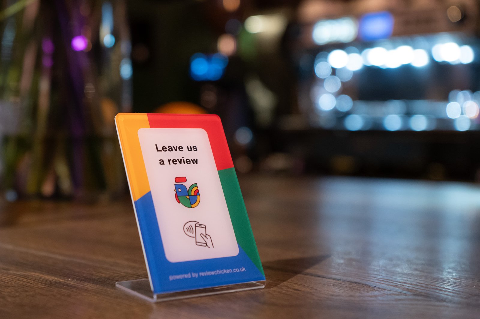 Customer tapping ReviewChicken stand – image 2. Helps local businesses collect more Google reviews quickly with NFC tap-to-review.