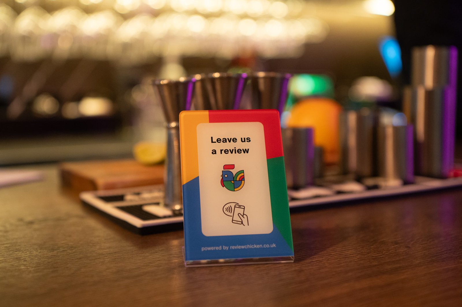 Customer tapping ReviewChicken stand – image 1. Helps local businesses collect more Google reviews quickly with NFC tap-to-review.