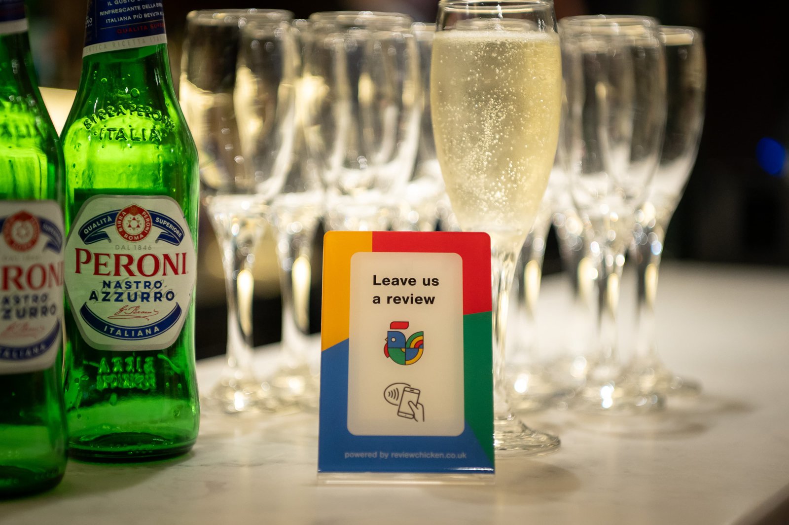 Customer tapping ReviewChicken stand – image 3. Helps local businesses collect more Google reviews quickly with NFC tap-to-review.